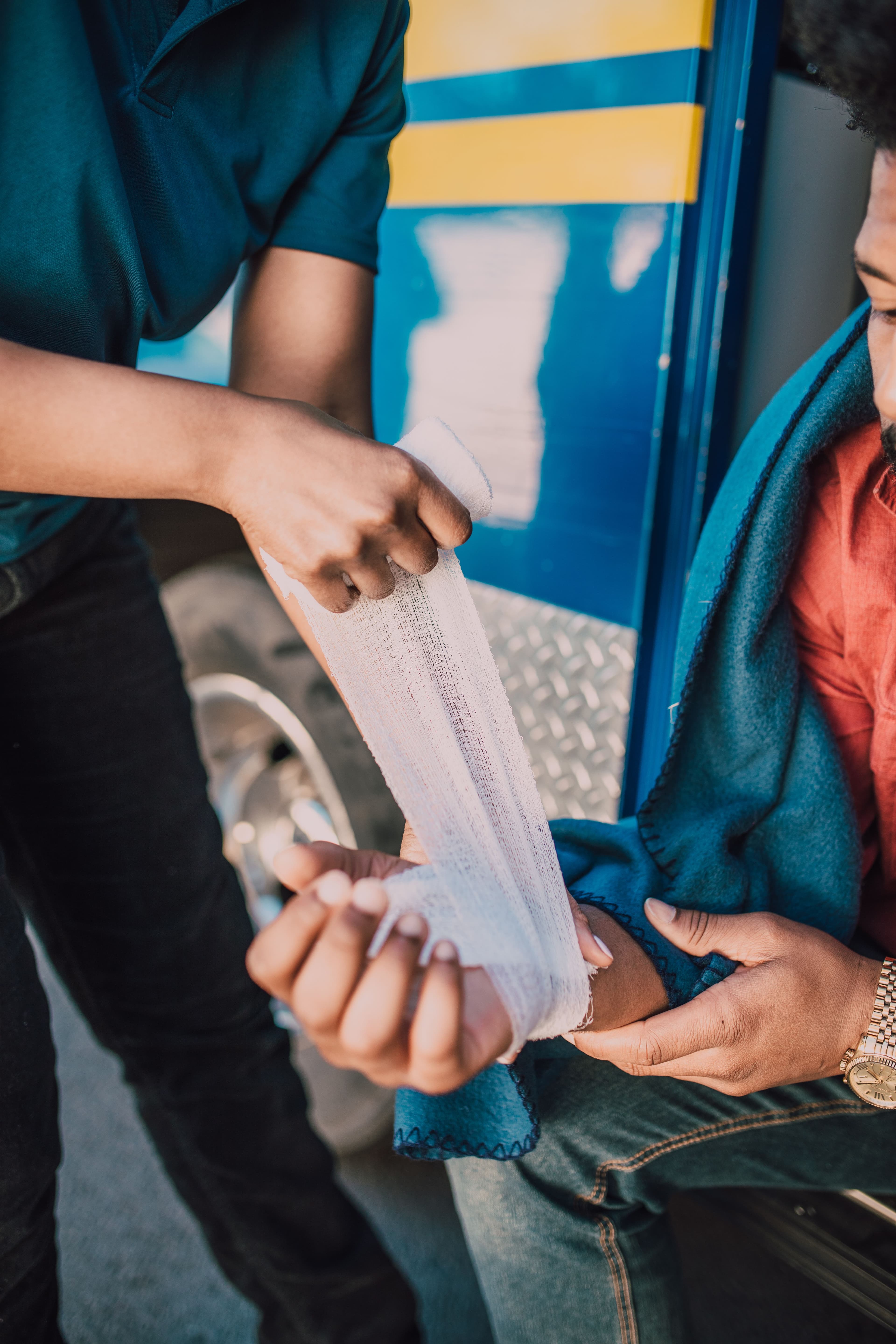 Provider wrapping an injured patient's hand and wrist with a gauze bandage