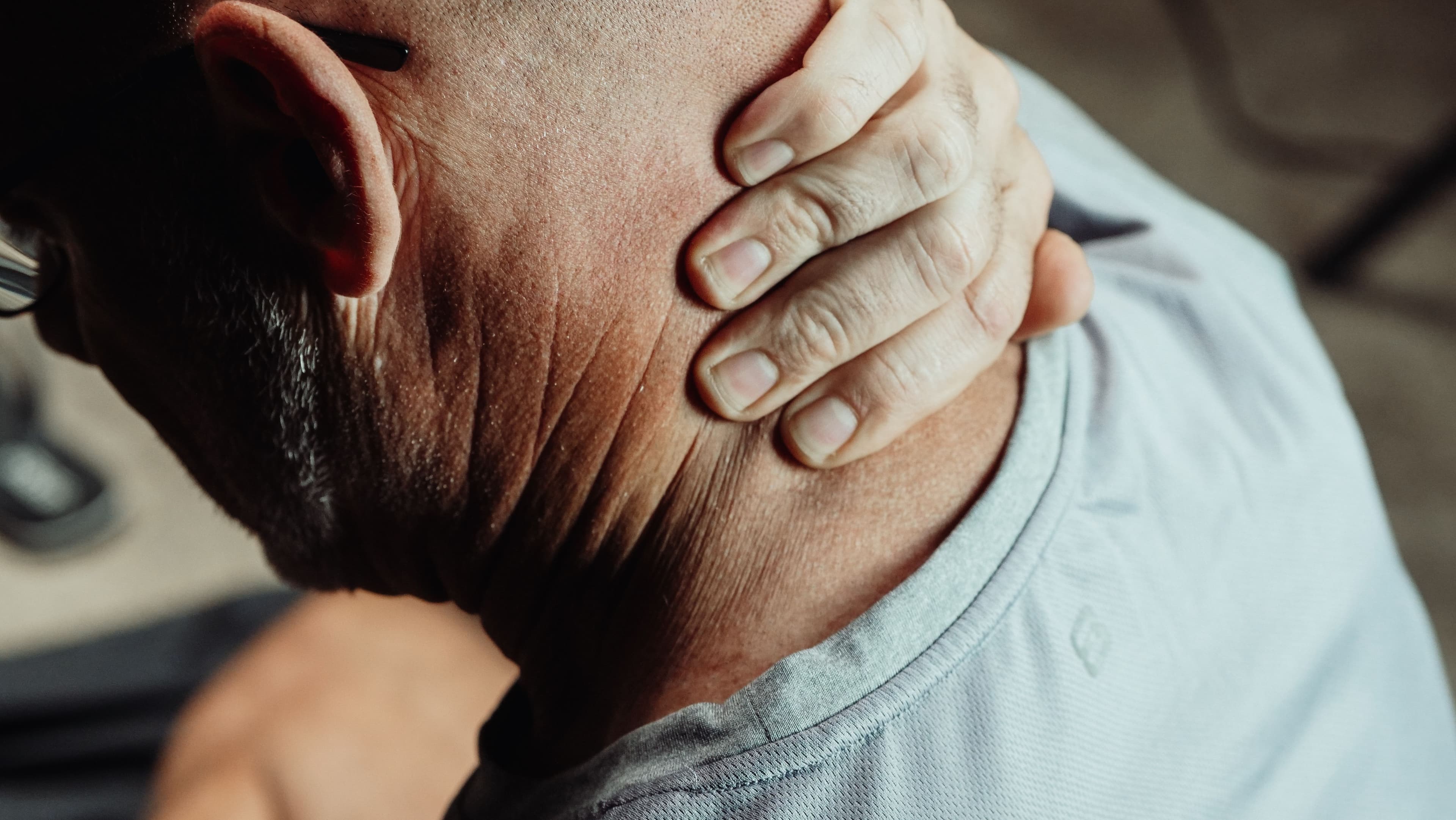Man rubbing a sore neck, a common injury after a car accident